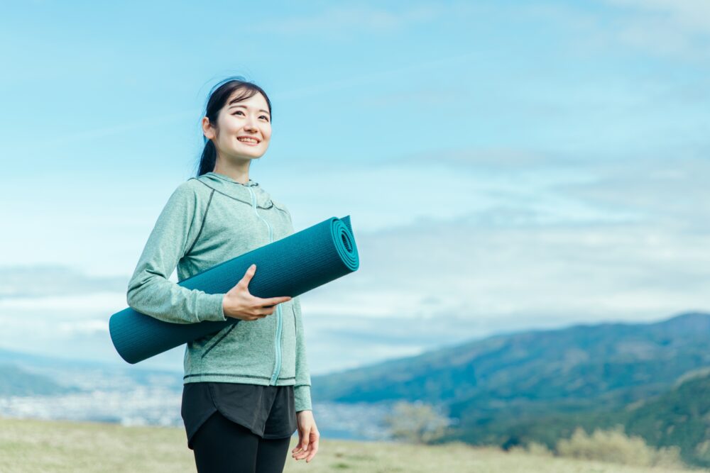 ヨガマットを持った女性